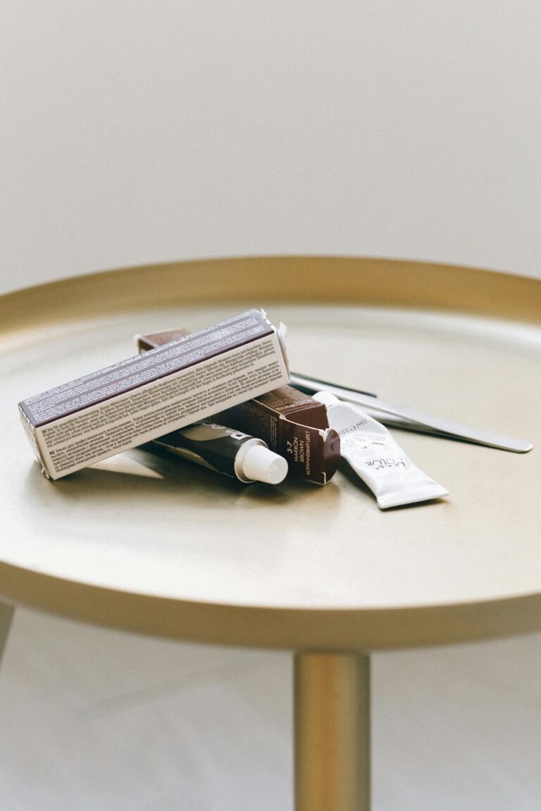 A collection of beauty products arranged on a minimalist round table indoors.